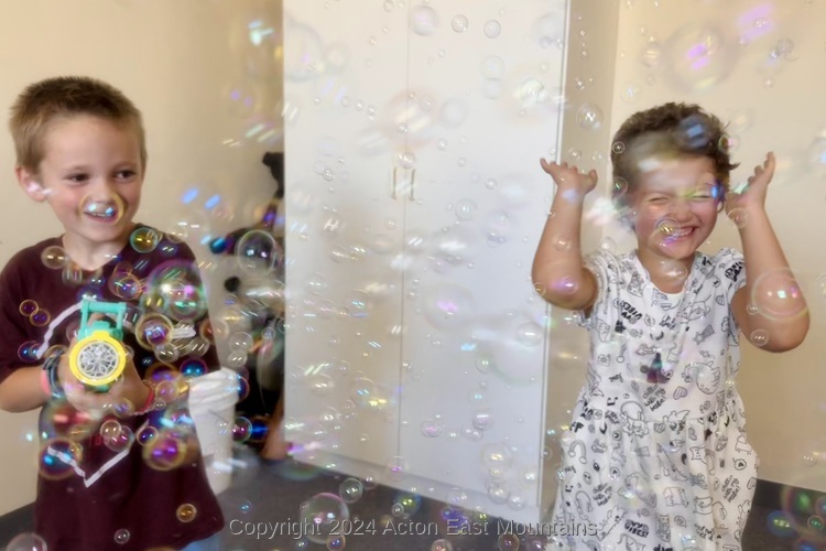 Learners at Acton Academy East Mountains private school in Cedar Crest, New Mexico happily playing with a bubble maker. 