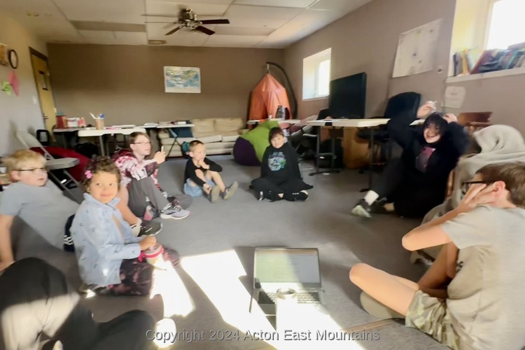 Acton Academy East Mountain learners sitting in a circle. 